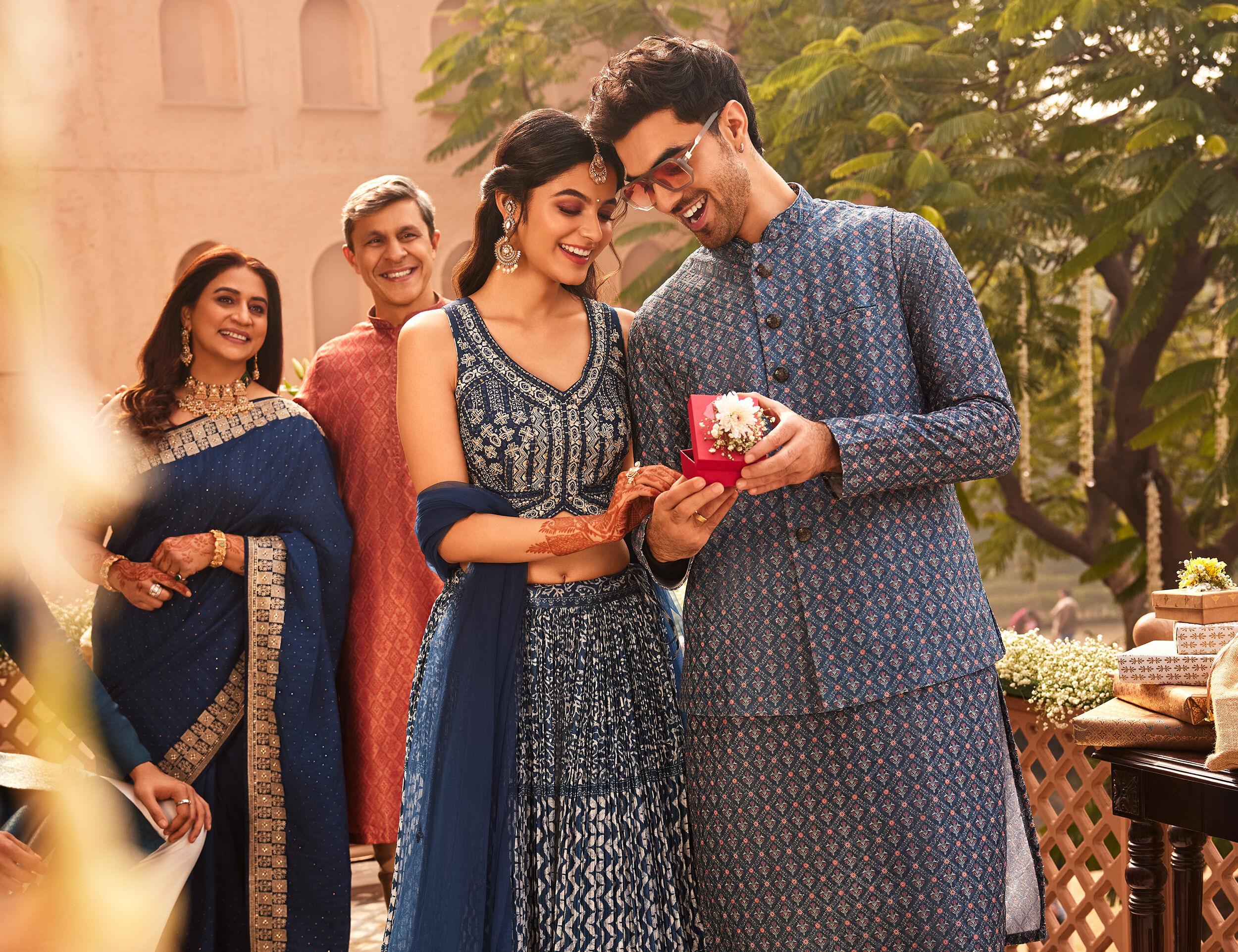 Bride wearing Blue and silver patterned lehenga and groom wearing Blue printed kurta jacket set
